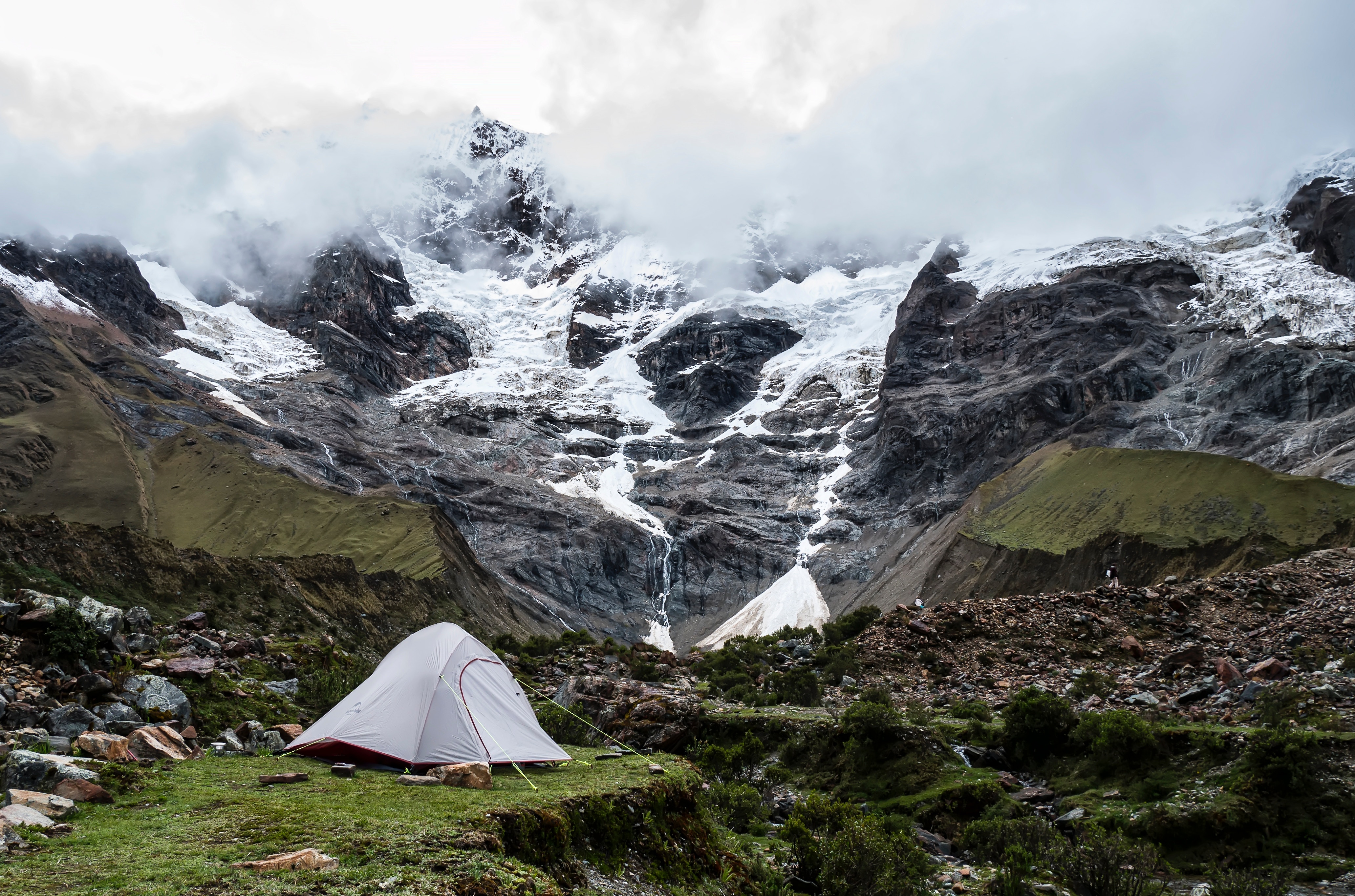 Grey tent with snow-capped mountains in background