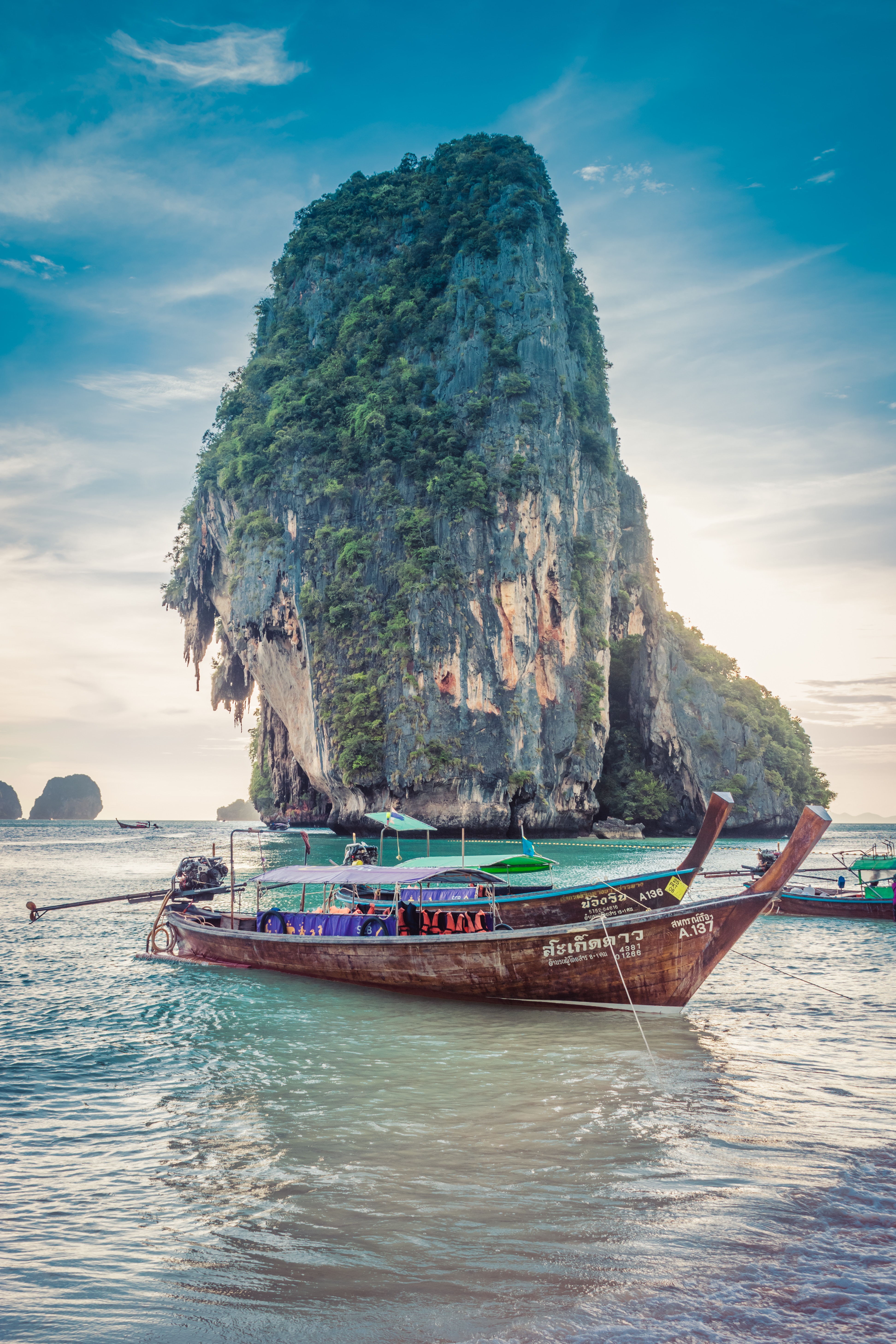 Thai fishing boat near large rock formation